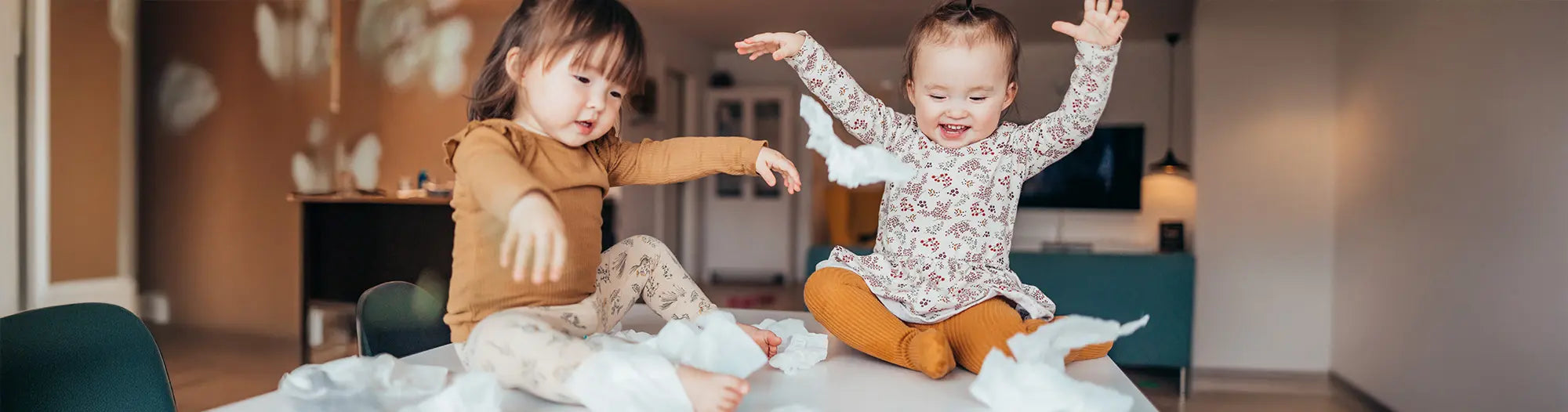 Two girls playing with Bambo Nature wet wipes on a table in a living room
